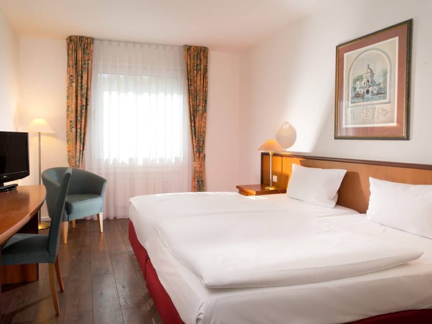 Helles Zimmer mit Schreibtisch und TV
