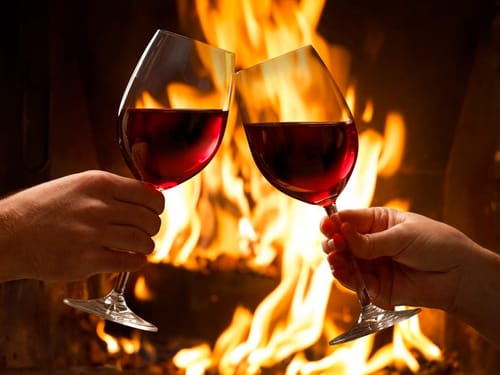 zwei Gläser Rotwein am Kamin