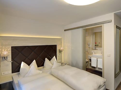 moderne und luxuriöse Suite mit Boxspringbett und direktem Zugang zum Bad