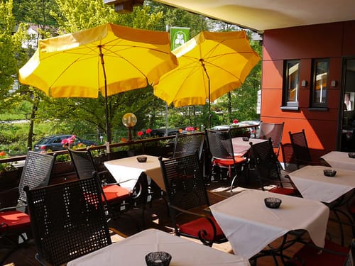 Hotelterrasse mit Gartenmöbeln und Sonnenschirmen