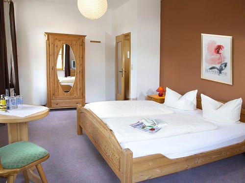 gemütliches Doppelzimmer mit Spiegelschrank, Doppelbett und kleinem Tisch