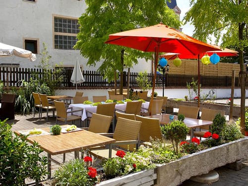 Hotelterrasse mit Rattan Gartenmöbeln und Sonnenschirmen