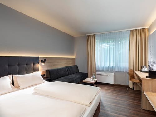 Doppelzimmer mit Boxspringbett, Schlafcouch, Schreibtsch und Kaffee und Teezubereiter