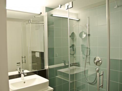 Bad mit Dusche, Waschtisch und Wandspiegel