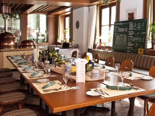 Hotel Restaurant mit gedeckter Tafel und Bierkrügen