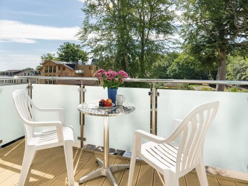 Balkon mit einem Tisch und zwei Stühlen