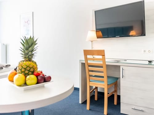 Schreibtisch, Stuhl, TV, Tisch mit Obst