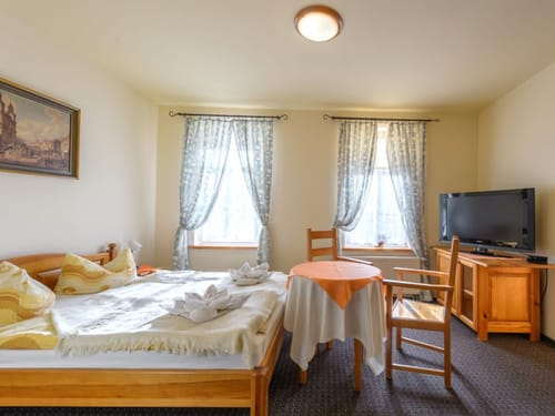 Standard Doppelzimmer mit Doppelbett, Tisch, zwei Stühlen und TV