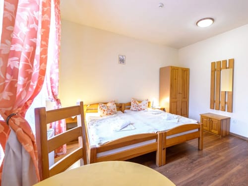 einfaches Doppelzimmer mit Doppelbett, Tisch, Stuhl und Kleiderschrank