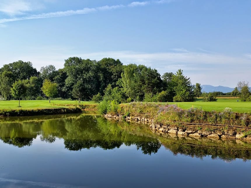 Golfplatz mit Teich bei Sonnenschein