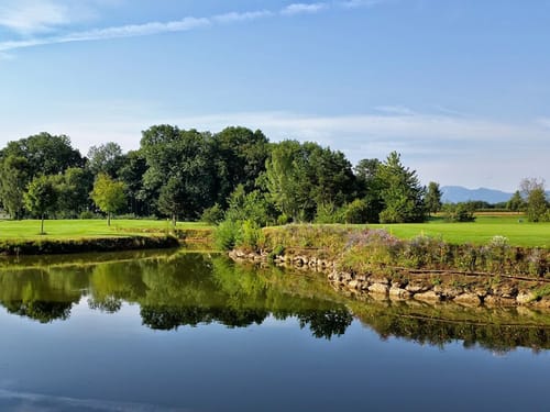 Golfplatz mit Teich bei Sonnenschein