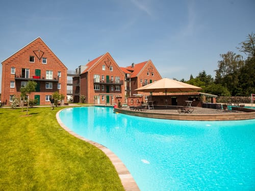 Moderner Wohnkomplex mit Backsteingebäuden und Swimmingpool im Vordergrund