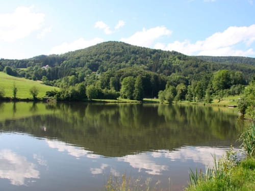 Malerische Landschaft mit grünem Hügel und ruhigem See