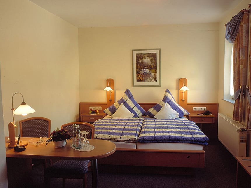 Standard Doppelzimmer mit Doppelbett, zwei Stühlen, Tisch und Nachttisch