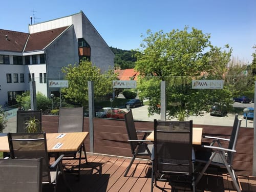 Terrasse mit Tischen und Stühlen