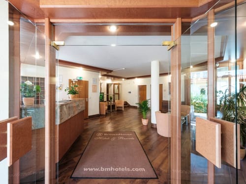 Hotel-Lobby mit Holzeinrichtung, Rezeption und Pflanzen
