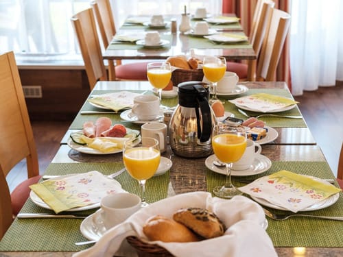 Frühstückstisch mit frischen Brötchen, Orangensaft und Aufschnitt