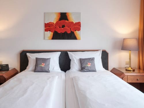 Modernes Twin-Bett-Hotelzimmer mit stilvoller Wanddekoration und Beleuchtung