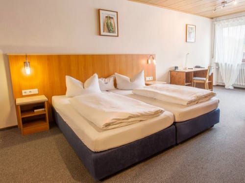 Zimmer mit Doppelbett und Schreibtisch