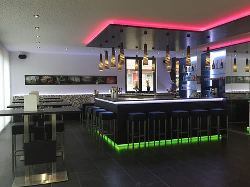 Moderne Bar mit stilvoller Beleuchtung und Sitzgelegenheiten