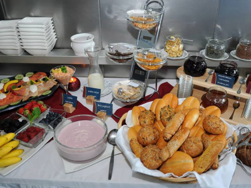 Reichhaltiges Frühstücksbuffet mit frischem Obst, Joghurt, Backwaren und Aufschnitt.