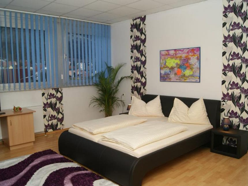 Modernes Schlafzimmer mit Doppelbett und stilvollen Dekorationsakzenten