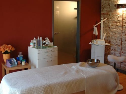 Gemütlicher Wellnessraum mit Massagetisch und entspannender Atmosphaere