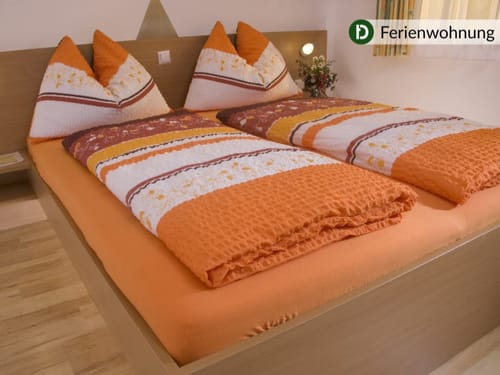 Gemütliches Schlafzimmer in einer Ferienwohnung mit Doppelbett und buntem Bettzeug