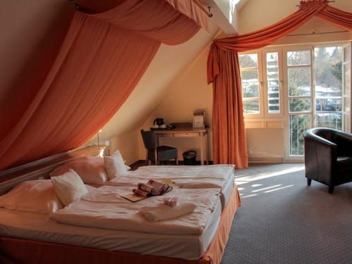 geräumiges Doppelzimmer mit Tisch, Sessel und Balkon