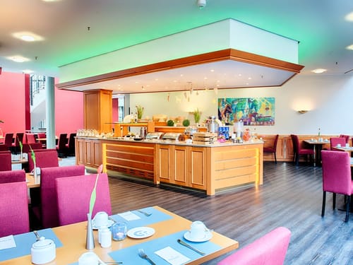 Speisesaal gedeckten Frühstückstischen und Speisenbuffet
