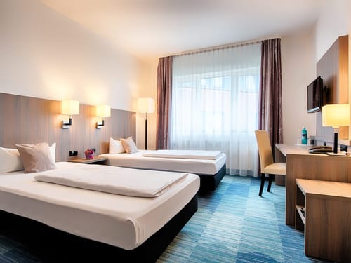 Doppelzimmer mit Twinbett, Schreibtisch, TV und Stuhl
