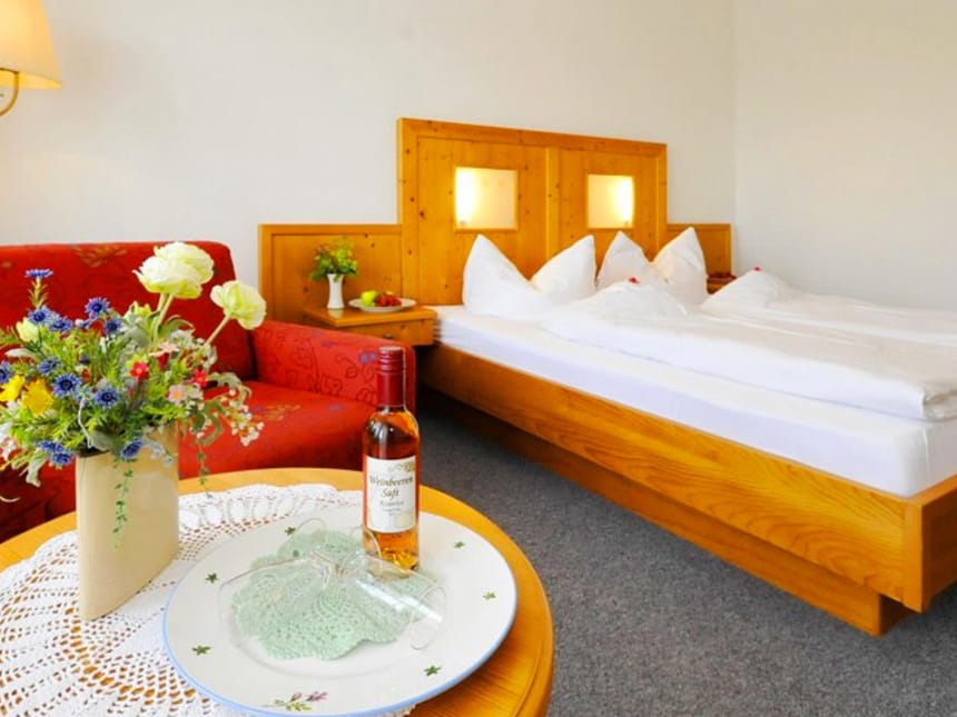 gemütliches Doppelzimmer mit Doppelbett, Couch und Tisch