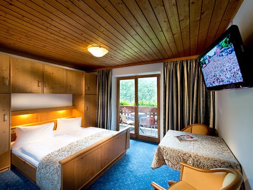 Doppelzimmer Standard mit Doppelbett, Wandschrank, Tisch und TV