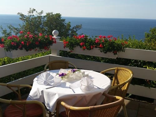 Terrasse mit gedecktem Tisch und Blick auf das Wasser