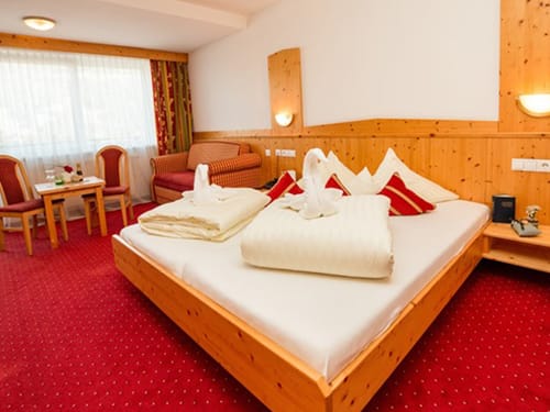 geräumiges Doppelzimmer mit zwei Stühlen, Tisch und Sessel
