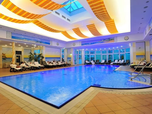 Indoor Pool mit Wellnessliegen am Rande