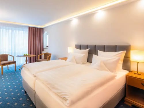 modernes Doppelzimmer Standard mit Boxspingbett, zwei Sesseln und Tisch