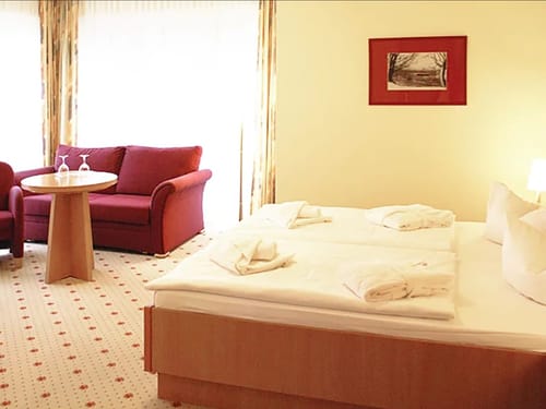 Doppelbett, Couch, Sessel und Tisch im Doppelzimmer