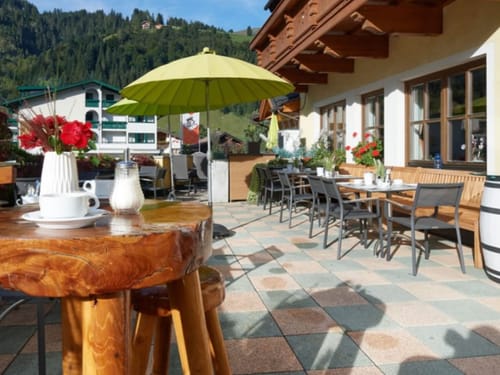 verschiedene Tischgruppen mit Sonnenschirme auf der Terrasse