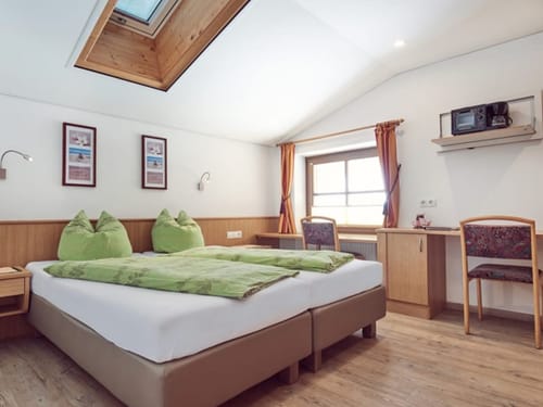 geräumiges Doppelzimmer mit Boxspringbett , Schreibtisch, Stühle und Dachfenster