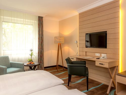 Modernes großes Zimmer mit TV, Schreibtisch und Sitzgruppe