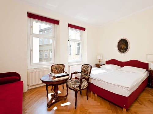 Doppelzimmer mit Doppelbett, Sessel, zwei Stühlen, Tisch und Leselampen