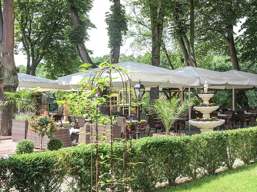 Terrasse mit Sonnenschirmen und Gartenmöbeln