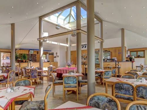 Lobby und Frühstücksbereich mit verschiedenen Tischgruppen