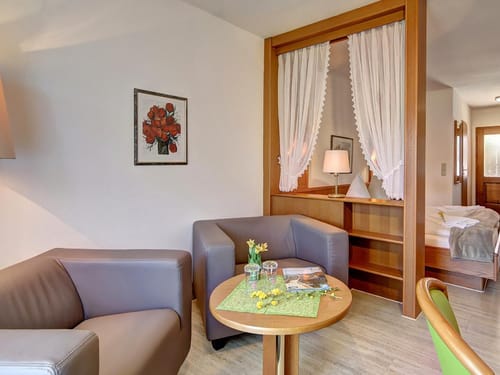 Sitzbereich im Doppelzimmer mit zwei Sesseln und Tisch
