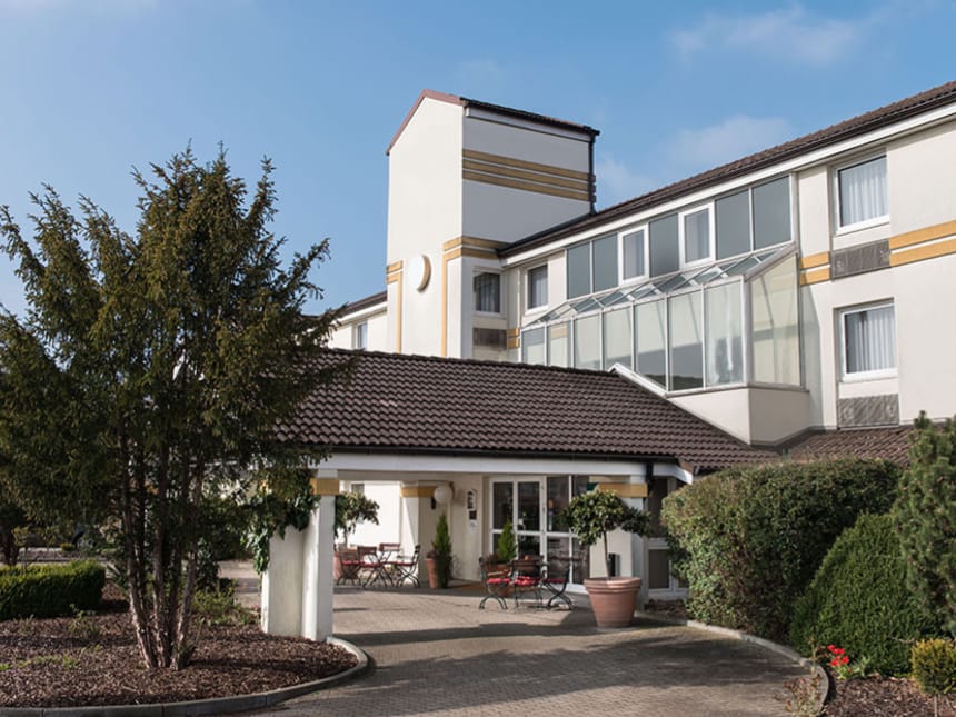 Modernes Hotelgebäude mit Glasfassade und Garten