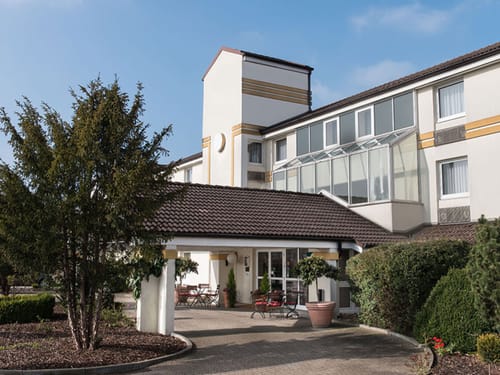 Modernes Hotelgebäude mit Glasfassade und Garten
