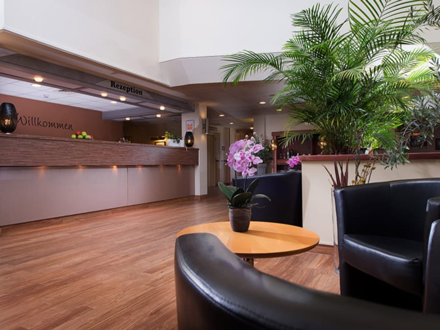 Empfangsbereich eines modernen Hotels mit Pflanzen und bequemen Sitzgelegenheiten