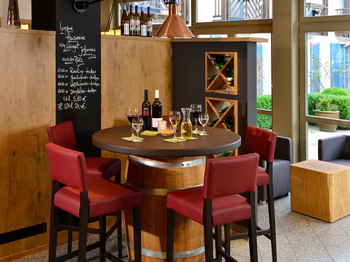 Tisch mit Stühlen und verschiedenen Weinen