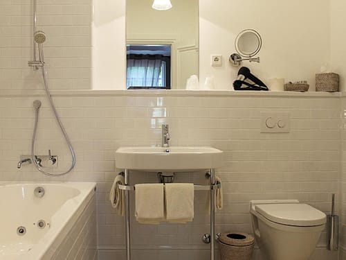 Badbereich mit Badewanne, Waschtisch, WC und Wandspiegel